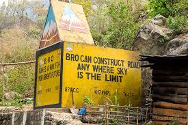 A Border Roads Organisation (BRO)  pillar in the mountainous region with the caption  BRO can construct anywhere sky is the limit.