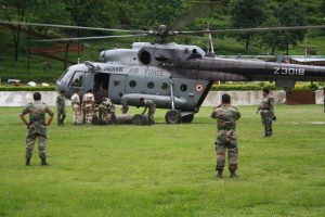 IAF helicopter getting loaded with flood relief stores for dropping in affected areas. IAF airmen loading the aircraft.