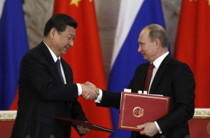 Russia's President Vladimir Putin (R) exchanges documents with his Chinese counterpart Xi Jinping 