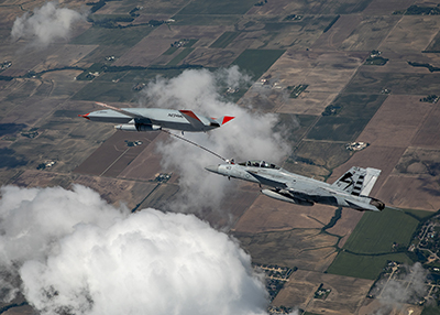 F/A - 18  gets refuelled by a Boeing MQ-25